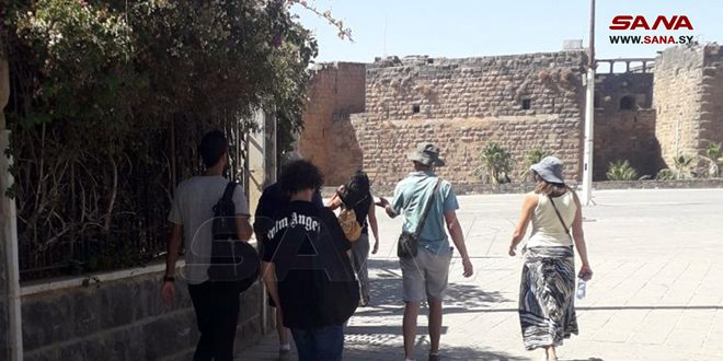 A tourist group of various nationalities visits Busra al-Sham